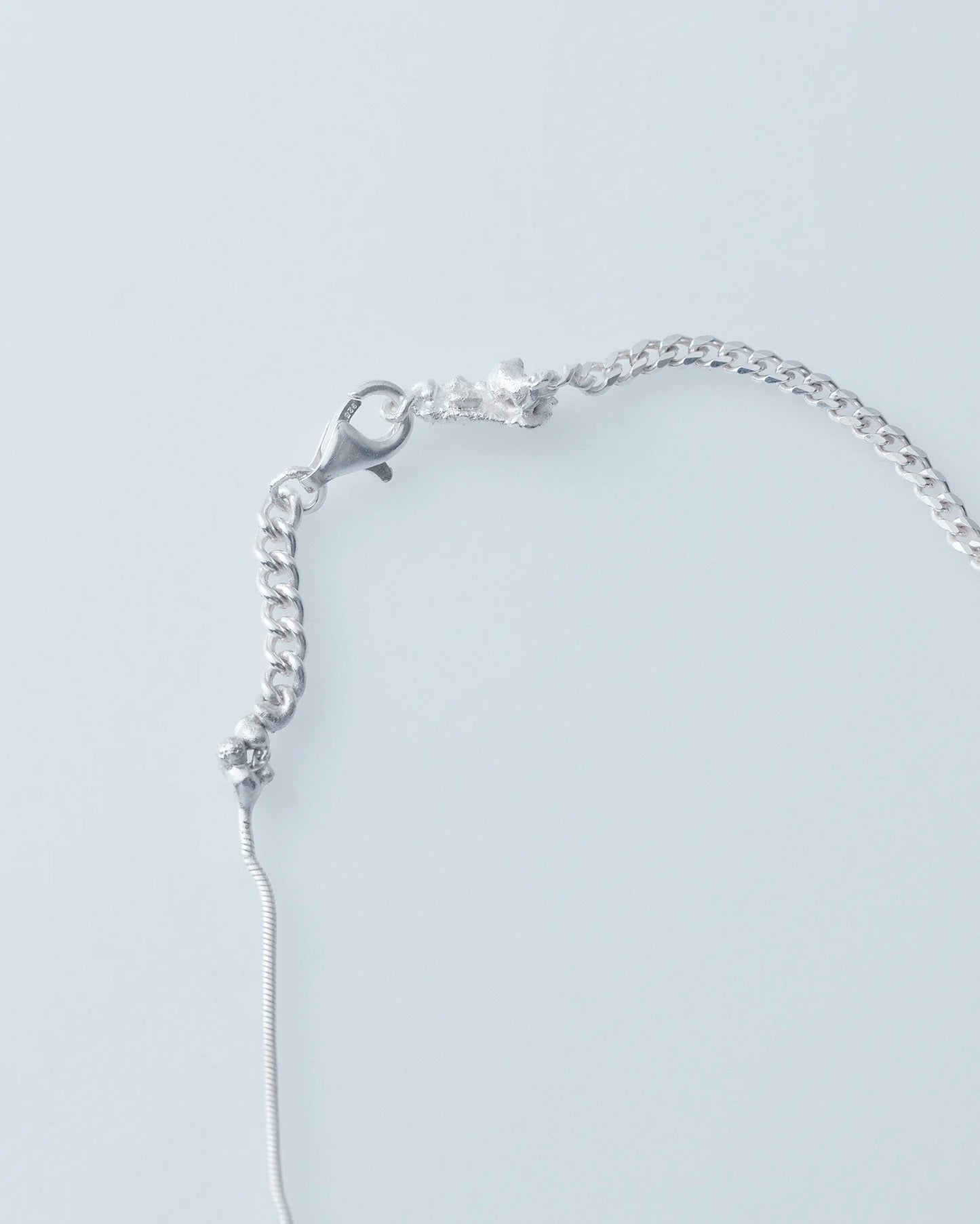 Silver bracelet on a light gray background