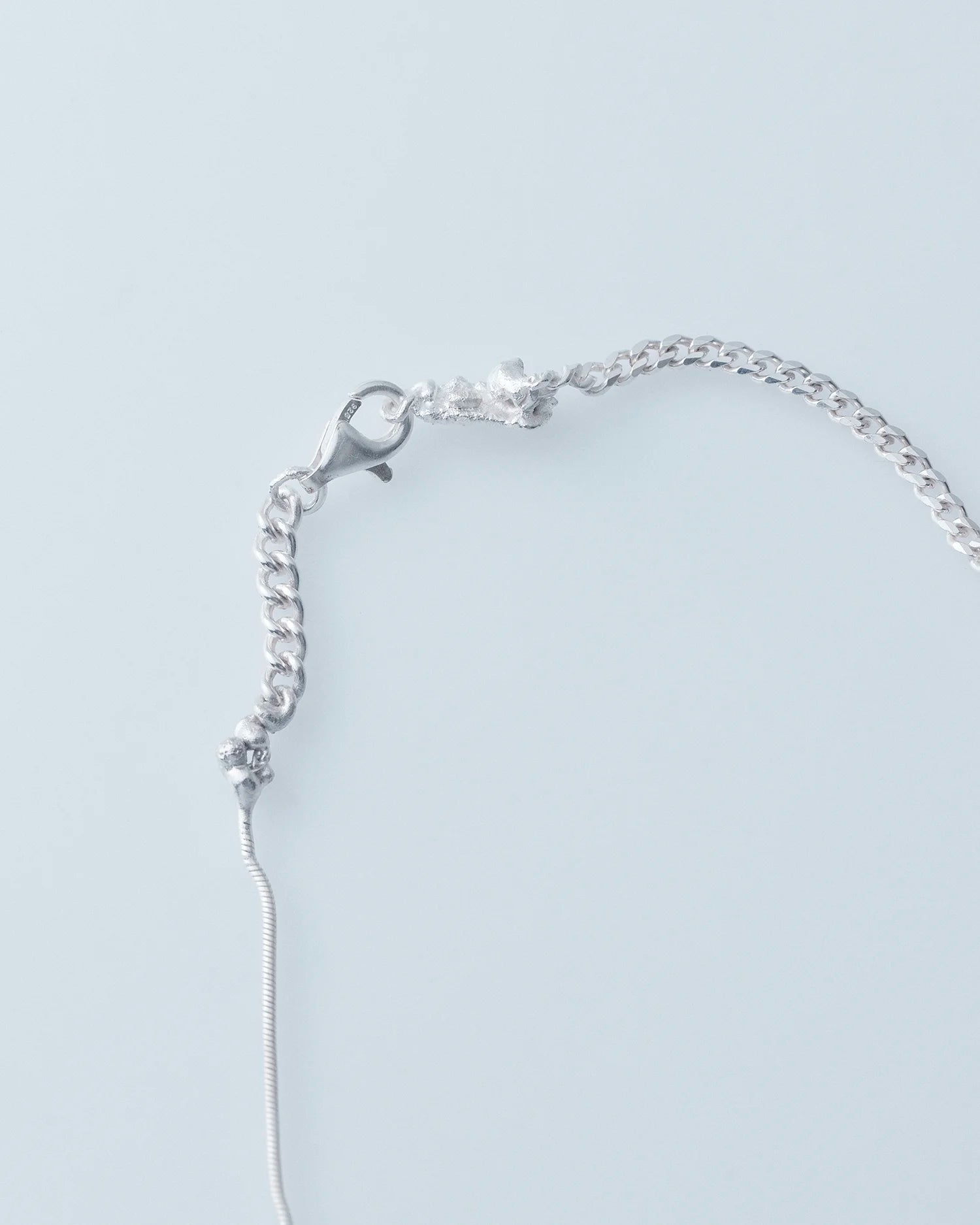 Silver bracelet on a light gray background